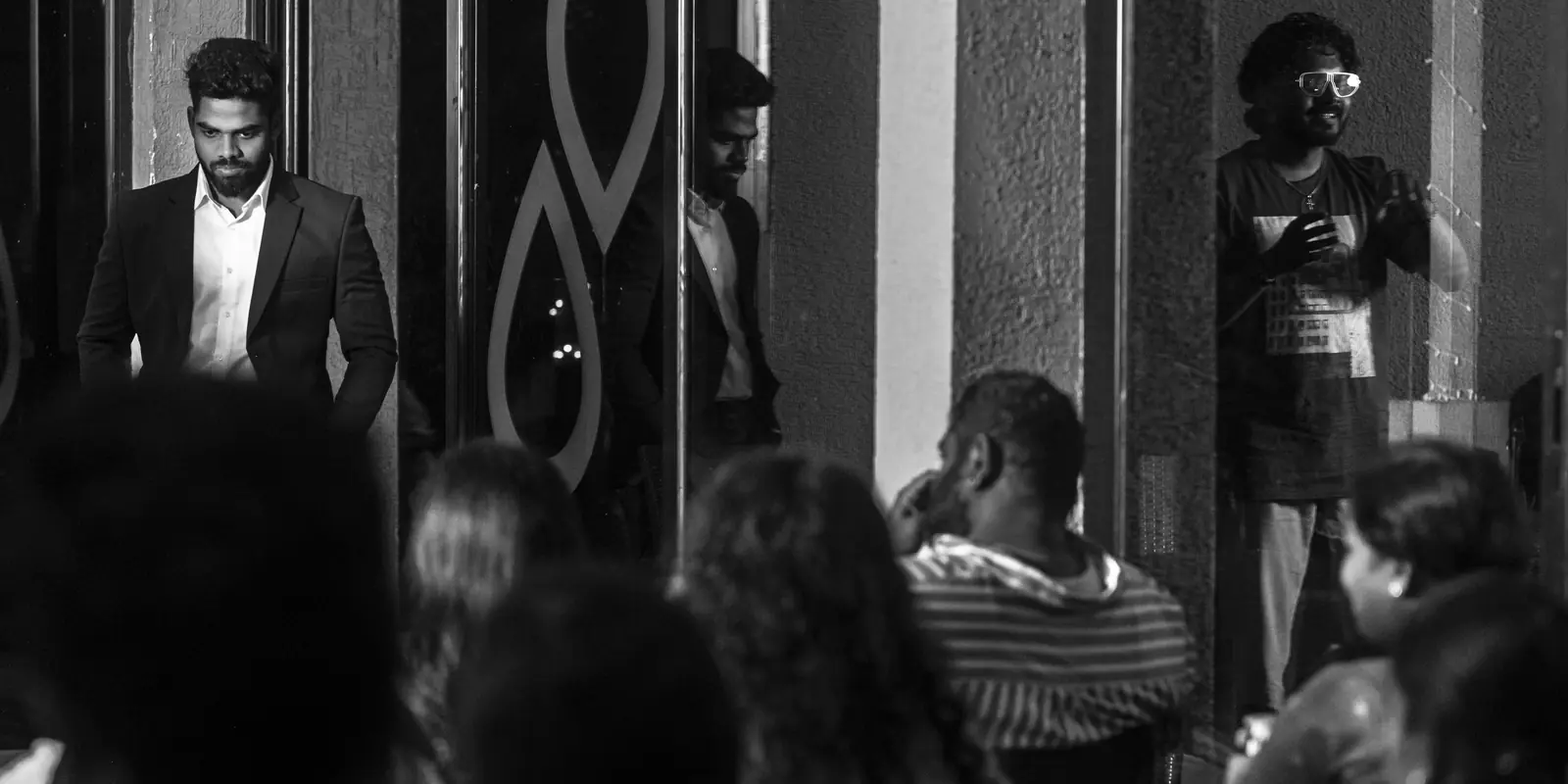 A founder standing at the glass wall with the seated room turned towards him