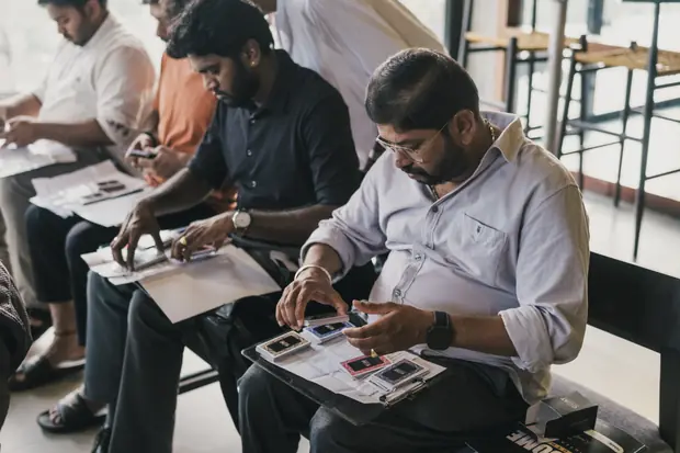 Founders comparing printed cards laid out across their laps