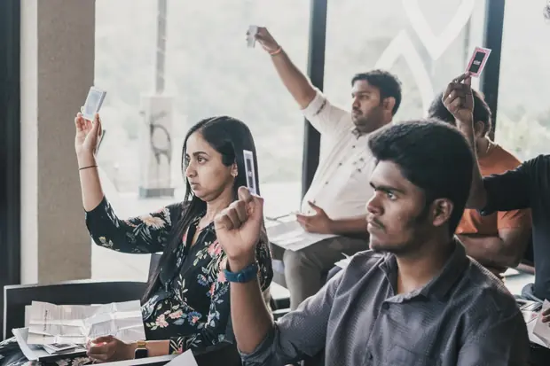 Founders holding printed cards up in the air during an exercise