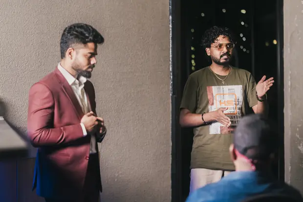 A founder standing to read from his notes while someone films on a phone